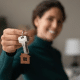 Mulher segurando a chave de uma casa.