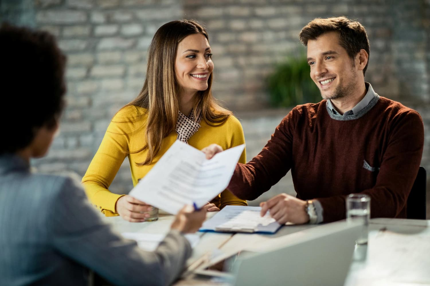 Casal feliz recebendo documentos de cota de consórcio